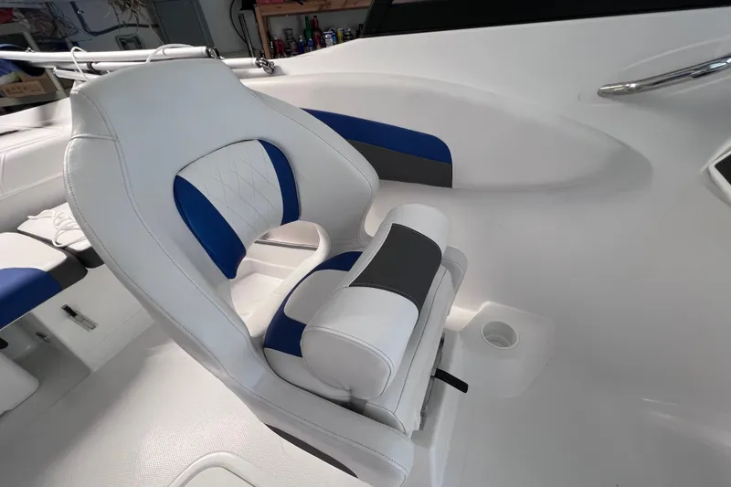 Slide: The Image of 2024 Tahoe 200 S boat interior with white and blue cushioned seating. - 25