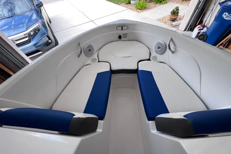 Slide: The Image of 2024 Tahoe 200 S boat interior with blue and white seating in a garage. - 30
