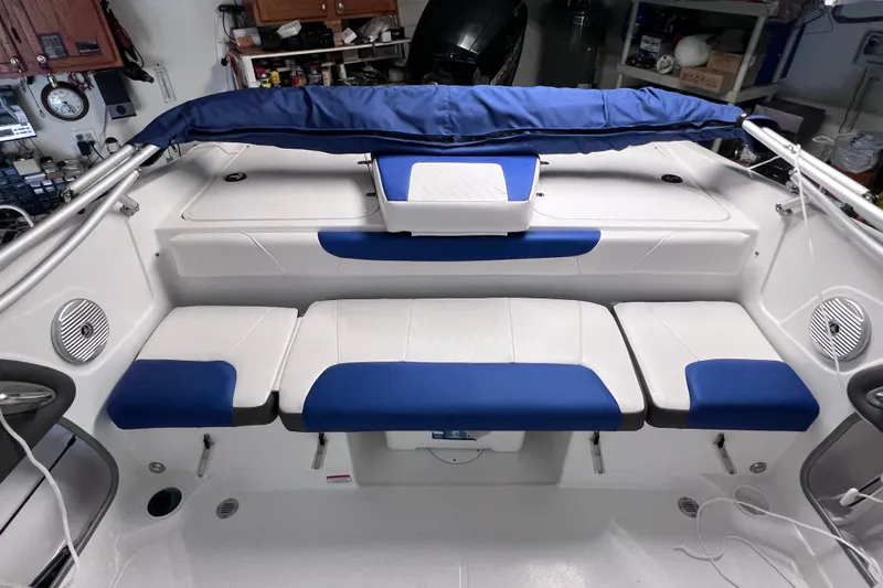 Slide: The Image of 2024 Tahoe 200 S boat interior with blue and white seating in a garage setting. - 17