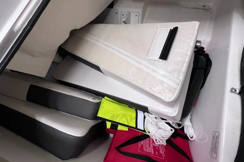 Slide: The Image of Storage compartment of 2024 Tahoe 200 S boat with safety gear and cushions. - 18