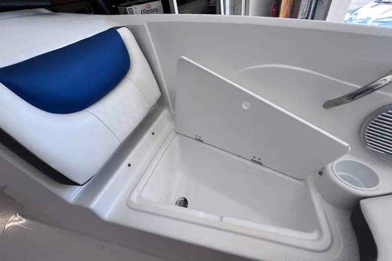 Slide: The Image of 2024 Tahoe 200 S boat interior with storage compartment and blue-accented seating. - 32