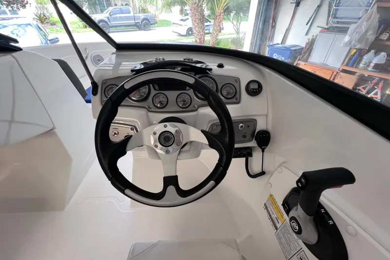 Slide: The Image of 2024 Tahoe 200 S boat dashboard with steering wheel and control panel. - 28
