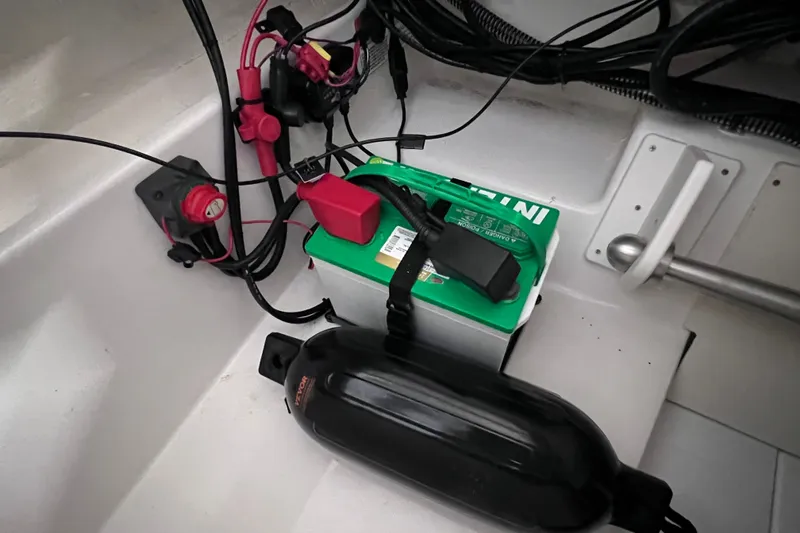 Slide: The Image of 2024 Tahoe 200 S boat battery compartment with wiring and components. - 19