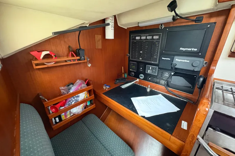 Slide: The Image of Navigation station in 2002 Caliber 40LRC yacht with Raymarine equipment and storage shelves. - 20