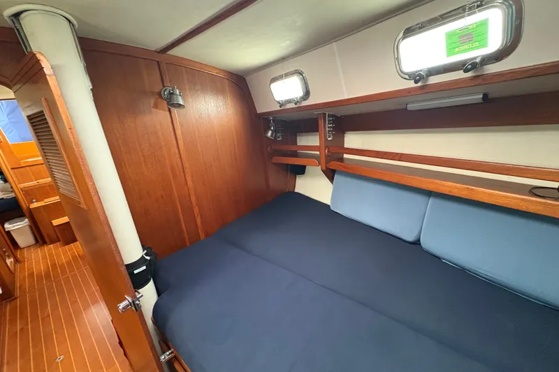 Slide: The Image of Cozy cabin interior of 2002 Caliber 40LRC sailboat with wooden finish and blue bedding. - 24