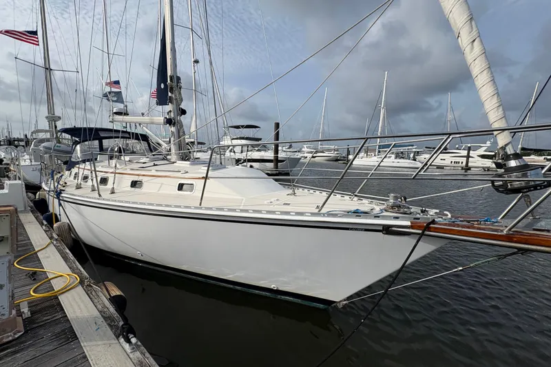 The Image of 2002 Caliber 40LRC sailboat docked at marina, surrounded by other boats under cloudy sky. - 1
