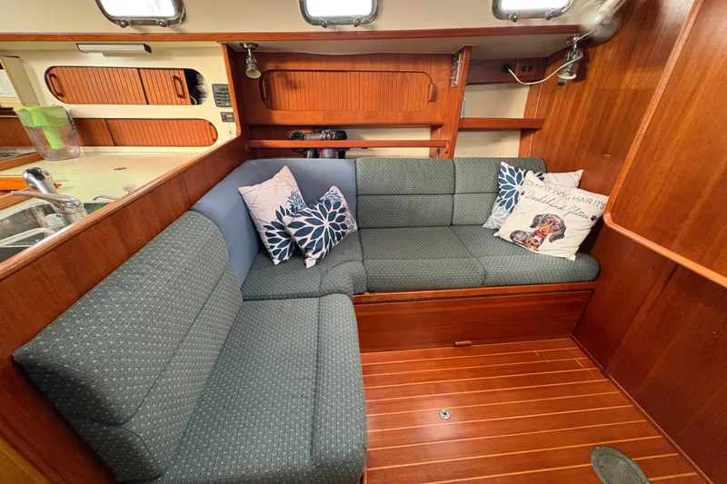 Slide: The Image of Cozy 2002 Caliber 40LRC yacht interior with cushioned seating and decorative pillows. - 31
