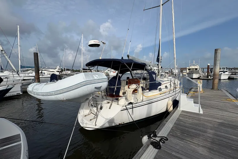 Slide: The Image of Sailboat Caliber 40LRC 2002 docked at marina with inflatable dinghy attached. - 2