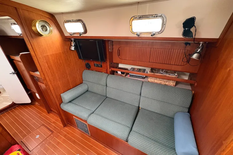Slide: The Image of 2002 Caliber 40LRC yacht interior with wooden paneling and cozy seating area. - 18