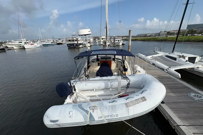 Slide: The Image of Sailboat Caliber 40LRC (2002) docked with inflatable dinghy, marina background. - 3