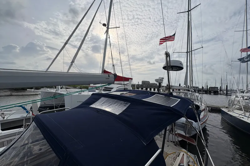 Slide: The Image of Sailboats docked at marina, featuring a 2002 Caliber 40LRC under a cloudy sky. - 12