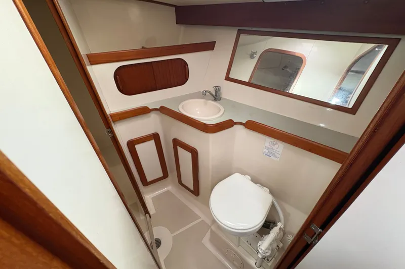 Slide: The Image of 2002 Caliber 40LRC yacht bathroom with sink, toilet, and wooden accents. - 16