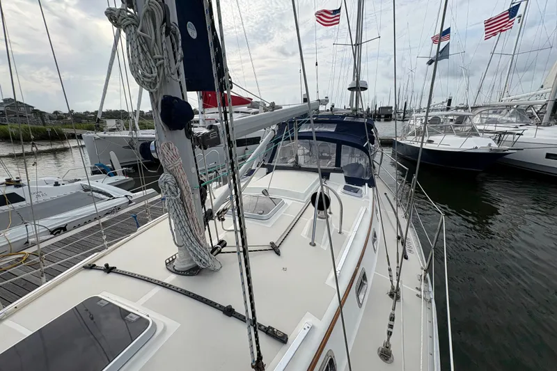 Slide: The Image of Sailboat docked at marina, 2002 Caliber 40LRC, with flags and rigging visible. - 6