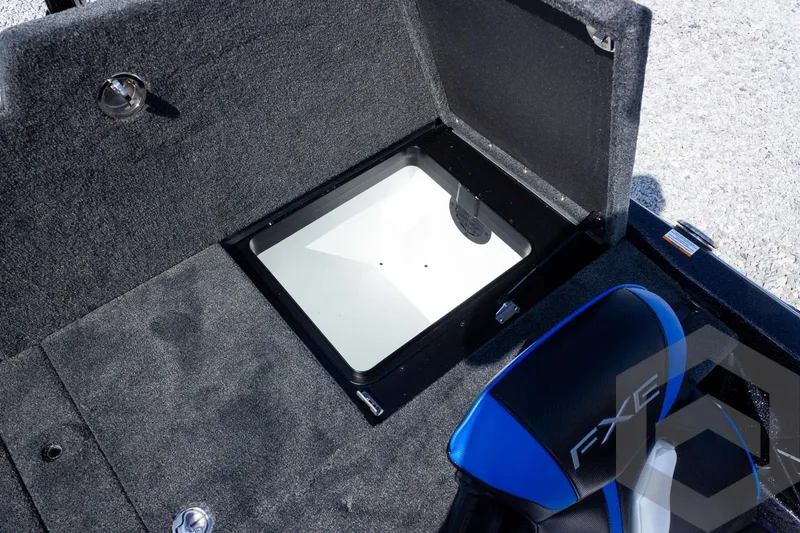 Slide: The Image of Open storage compartment in 2027 Skeeter FXE20 Pro boat with blue-accented seat. - 23