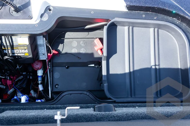 Slide: The Image of Open storage compartment of 2027 Skeeter FXE20 Pro boat, showing wiring and battery setup. - 25