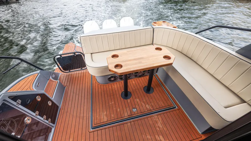 Slide: The Image of The image shows the deck of a 2027 Hanover 415 boat with sleek seating and a wooden table. - 25