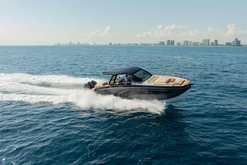 Slide: The Image of 2026 Hanover 447 boat cruising on open water with city skyline in background. - 1