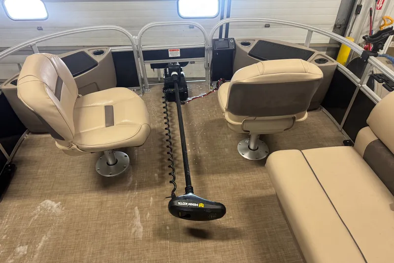 Slide: The Image of 2021 Sun Tracker Fishin' Barge 20 DLX interior with beige seating and trolling motor. - 21
