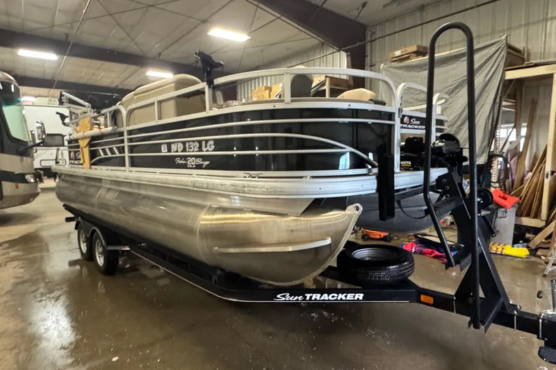 The Image of 2021 Sun Tracker Fishin' Barge 20 DLX pontoon boat in indoor storage. - 0