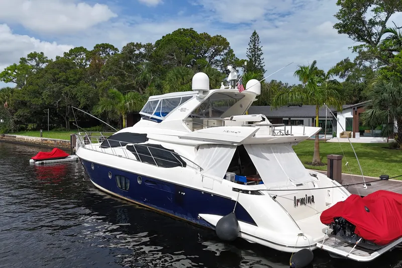 Slide: The Image of 2008 Azimut 62E yacht docked by lush greenery and waterfront homes. - 61