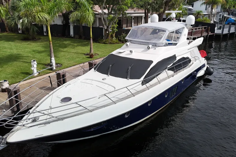 Slide: The Image of 2008 Azimut 62E yacht docked by lush greenery and waterfront homes. - 62