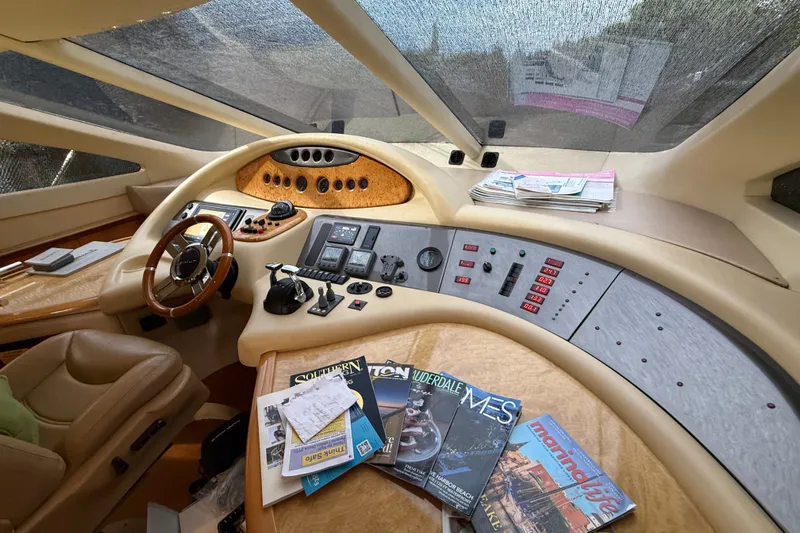 Slide: The Image of Cockpit of 2008 Azimut 62E yacht with steering wheel, controls, and nautical magazines. - 30