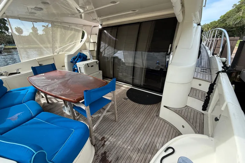 Slide: The Image of Luxurious 2008 Azimut 62E yacht deck with blue seating and wooden table. - 18