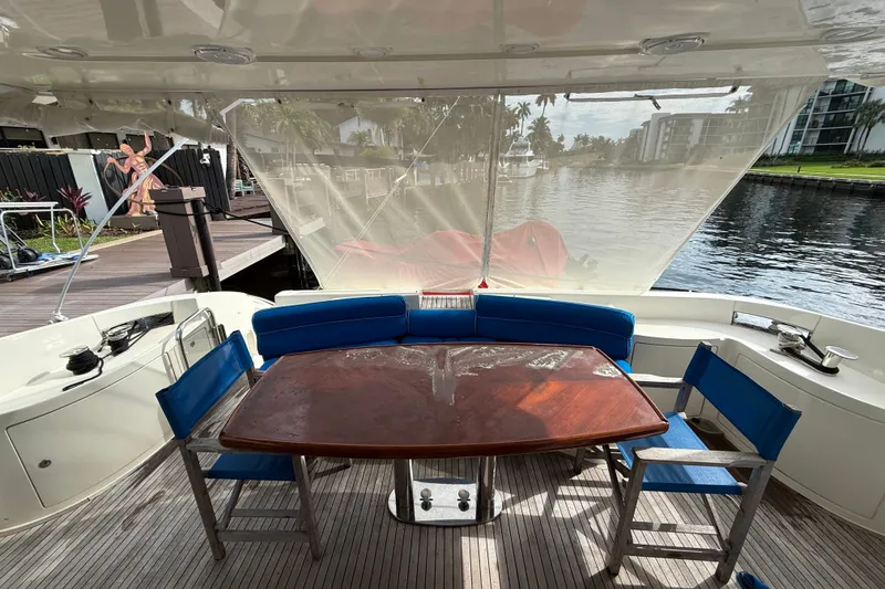 Slide: The Image of 2008 Azimut 62E yacht deck with wooden table, blue chairs, and waterfront view. - 19