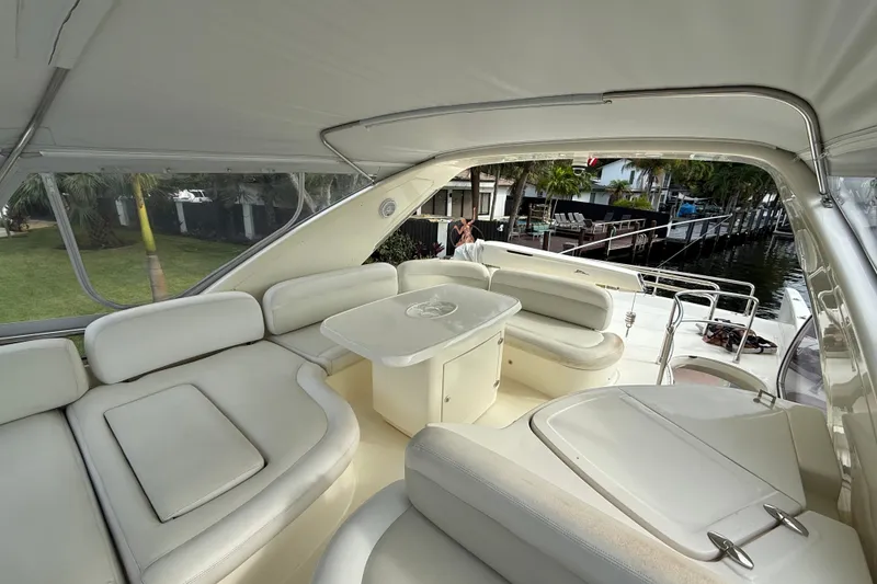 Slide: The Image of Luxurious 2008 Azimut 62E yacht interior with elegant seating and table, docked by waterfront. - 6
