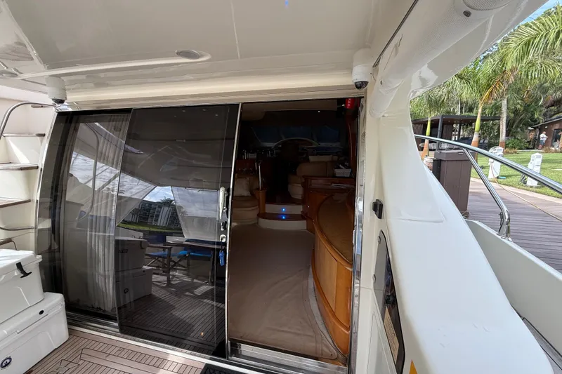 Slide: The Image of 2008 Azimut 62E yacht interior view with sliding glass door and luxurious wooden furnishings. - 20