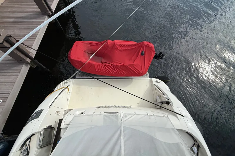 Slide: The Image of 2008 Azimut 62E yacht docked, featuring a red-covered dinghy on the stern. - 14
