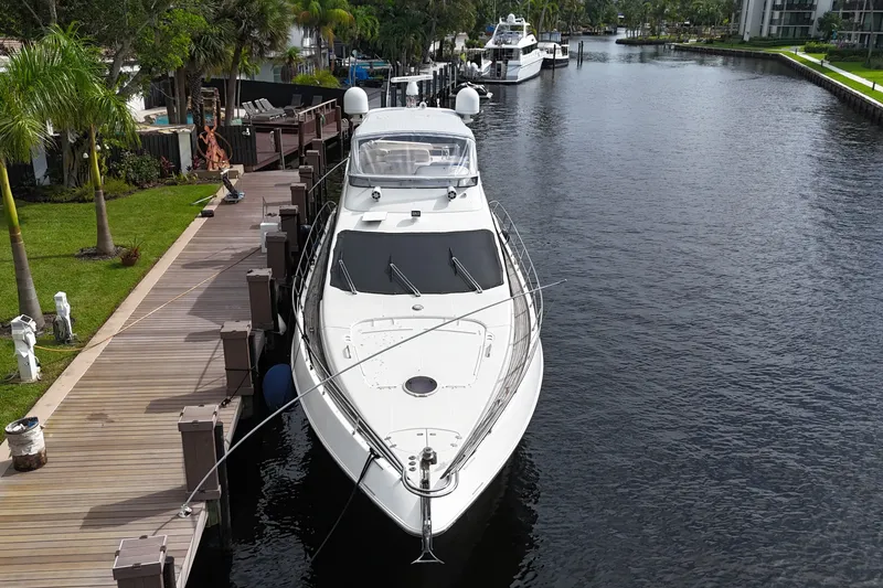 Slide: The Image of 2008 Azimut 62E yacht docked by a scenic waterfront with lush greenery. - 63