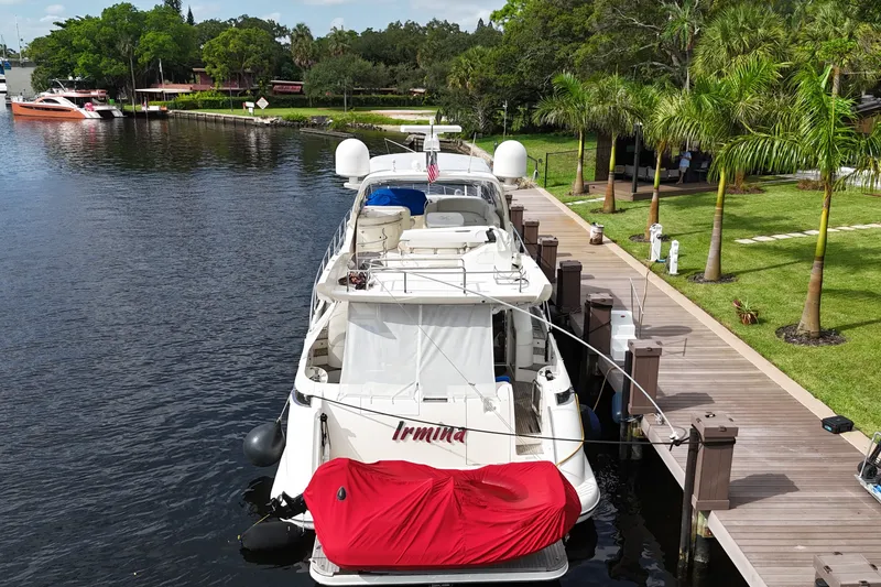 Slide: The Image of 2008 Azimut 62E yacht docked by a lush, palm-lined waterfront. - 3