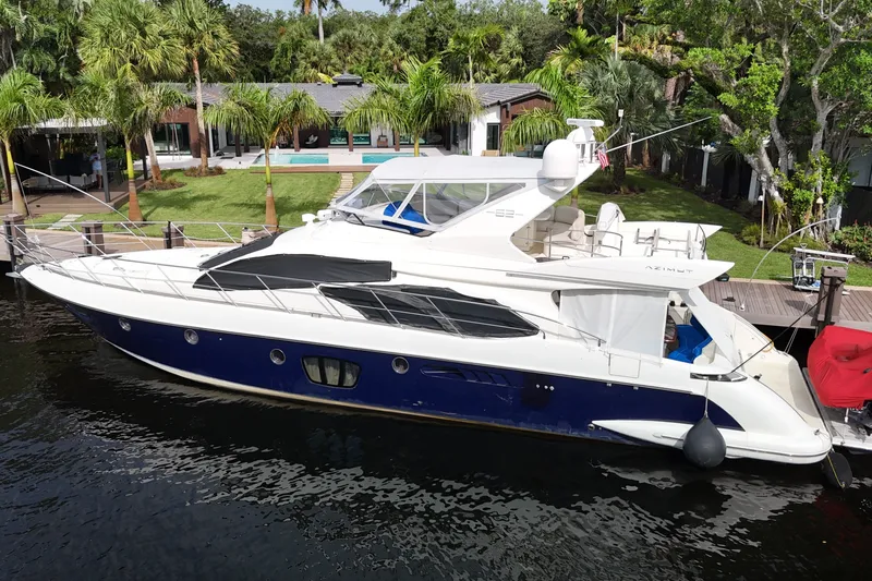 Slide: The Image of 2008 Azimut 62E yacht docked by a lush waterfront property. - 65