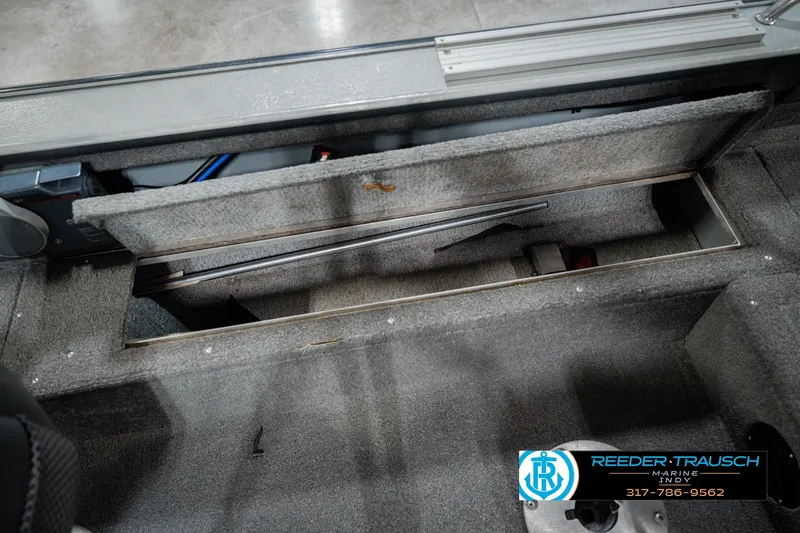 Slide: The Image of Interior storage compartment of a 1999 Lund Mr. Pike 17 boat, featuring carpeted finish. - 28