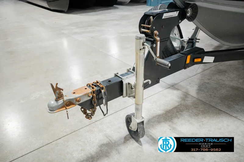 Slide: The Image of Trailer hitch of a 1999 Lund Mr. Pike 17 boat, featuring chains and a wheel jack. - 59