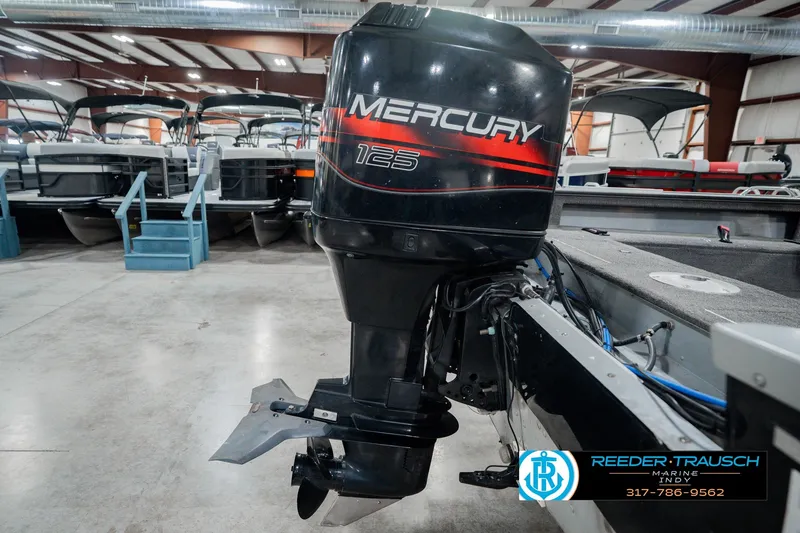 Slide: The Image of 1999 Lund Mr. Pike 17 with Mercury 125 outboard motor in a showroom. - 46
