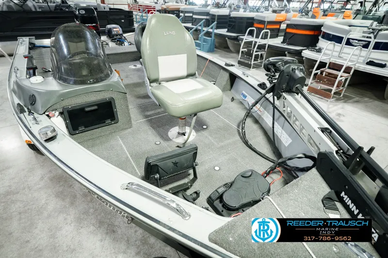 Slide: The Image of 1999 Lund Mr. Pike 17 fishing boat interior with seating and equipment in showroom. - 13