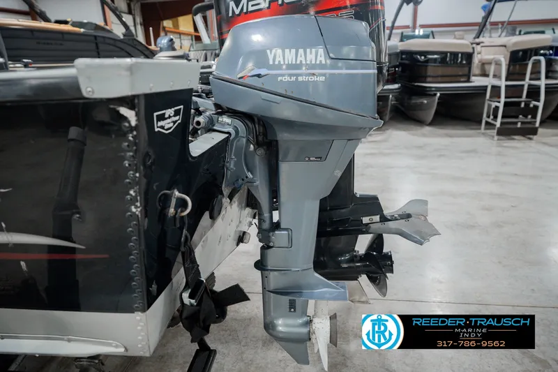 Slide: The Image of 1999 Lund Mr. Pike 17 boat with Yamaha four-stroke outboard motor in showroom. - 50