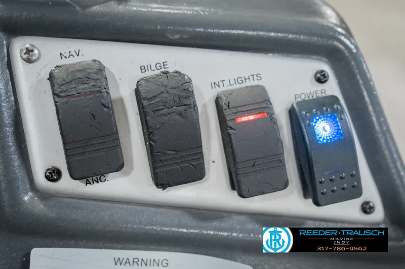 Slide: The Image of Control panel of a 1999 Lund Mr. Pike 17 boat with labeled switches. - 37