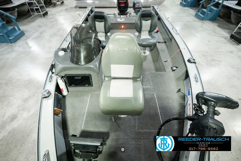 Slide: The Image of 1999 Lund Mr. Pike 17 fishing boat interior with seating and equipment in showroom. - 21