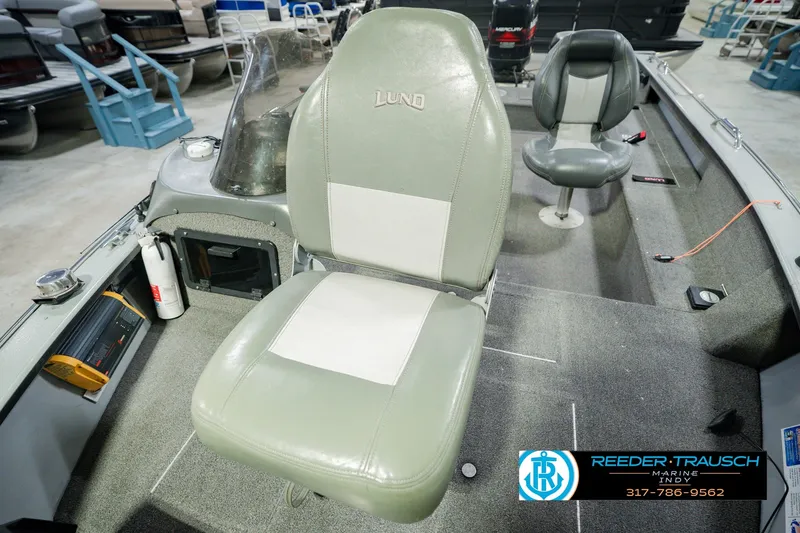Slide: The Image of 1999 Lund Mr. Pike 17 boat interior with seating and equipment, displayed in a showroom. - 41