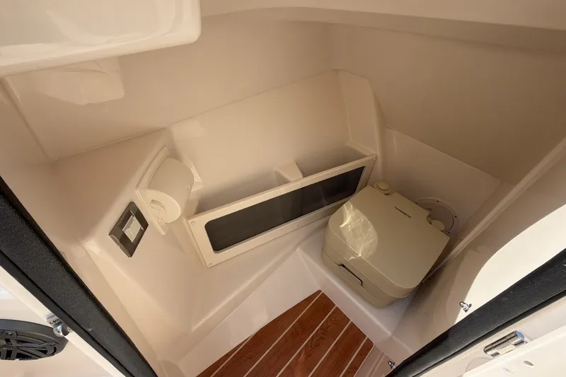 Slide: The Image of Interior view of a boat cabin with a toilet, wooden flooring, and storage space. - 12
