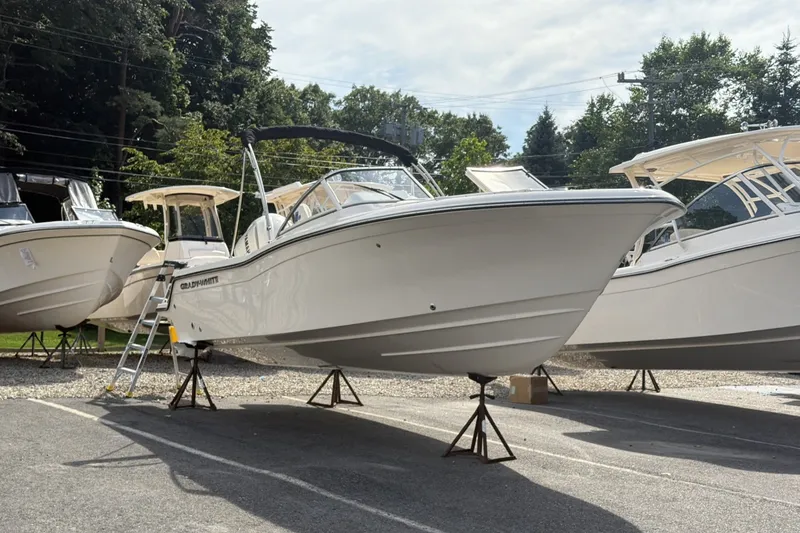 Slide: The Image of 2027 Grady-White Freedom 215 on a lot, surrounded by other boats. - 2