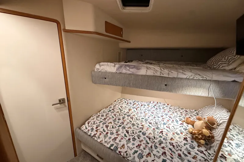 Slide: The Image of Interior cabin of 1994 Sea Ray 500 Sundancer with cozy bunk beds and plush toys. - 34