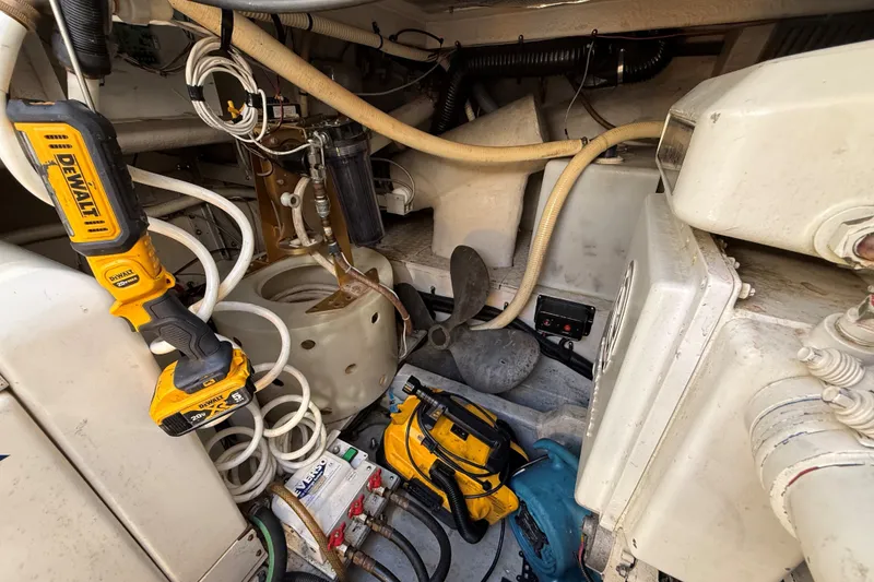 Slide: The Image of Engine room of a 1994 Sea Ray 500 Sundancer with tools and equipment. - 54