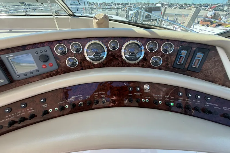 Slide: The Image of 1994 Sea Ray 500 Sundancer dashboard with gauges and controls at marina. - 15