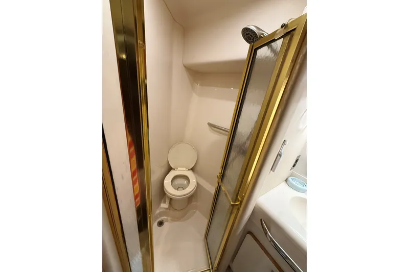 Slide: The Image of Bathroom with shower in 1994 Sea Ray 500 Sundancer yacht, featuring gold accents. - 38