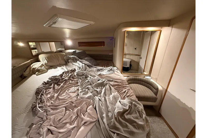 Slide: The Image of Cozy cabin interior of 1994 Sea Ray 500 Sundancer with unmade bed and soft lighting. - 44