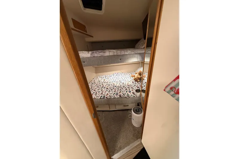 Slide: The Image of Interior cabin of 1994 Sea Ray 500 Sundancer with bunk beds and cozy decor. - 33